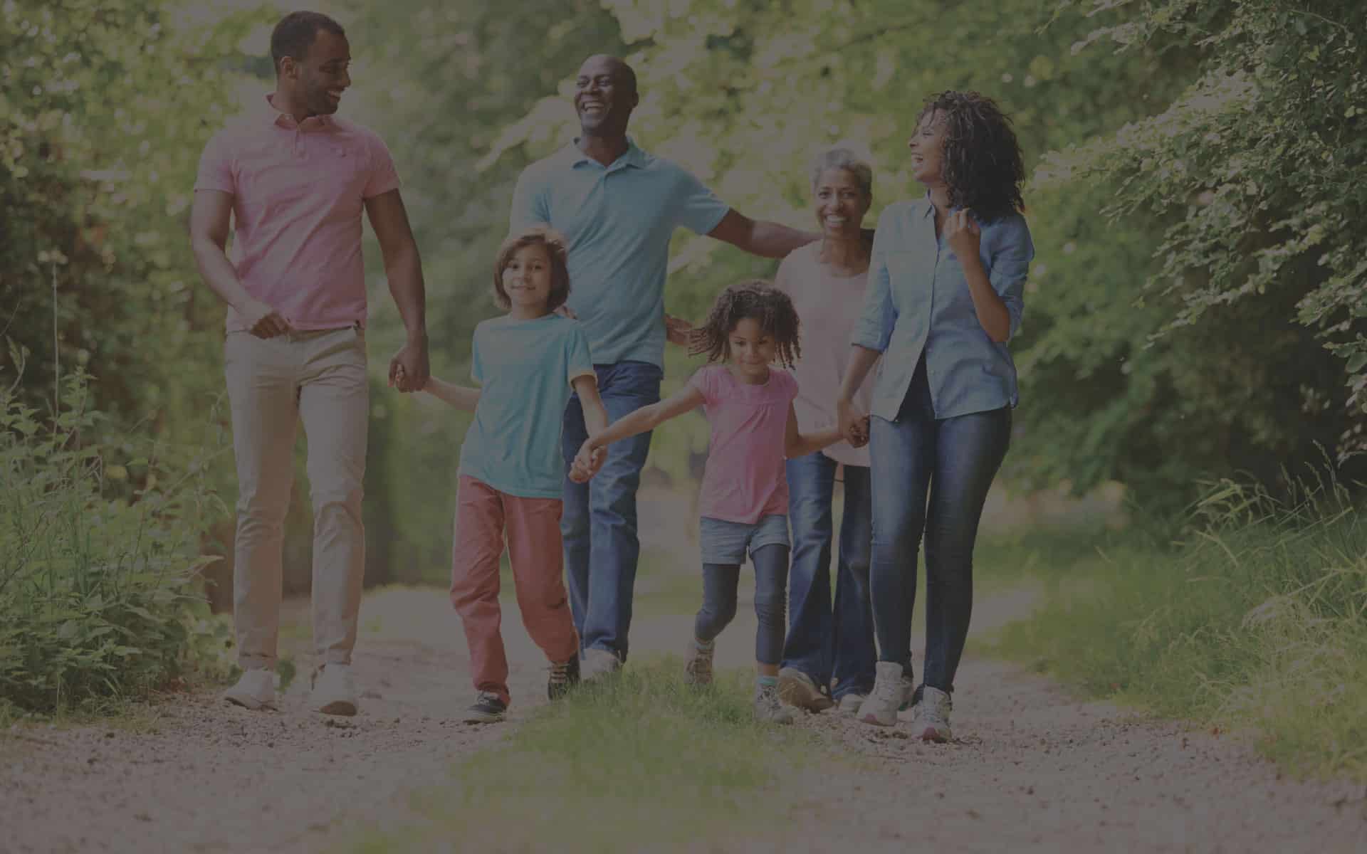 Family walking together in a park, enjoying time outdoors, reflecting the importance of community and support in home buying and mortgage financing.