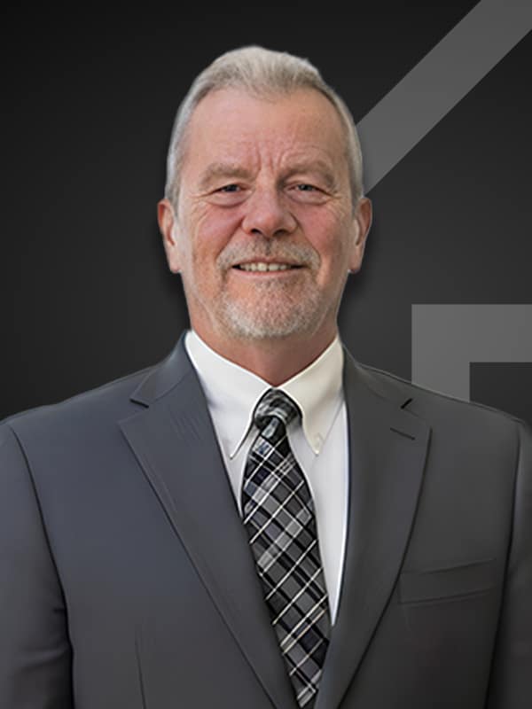 Frank Essek, Senior Loan Officer at Kash Mortgage Group, smiling in a suit and tie against a dark background, showcasing his professional demeanor and experience in the mortgage industry.