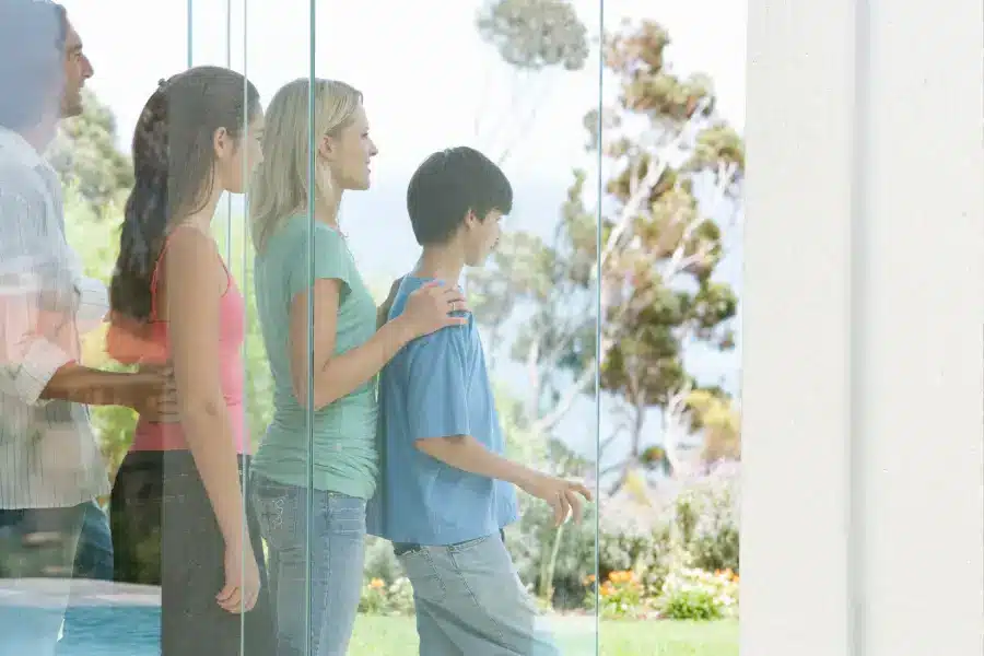 Happy family standing together in a bright, modern home, symbolizing the joy of homeownership and community, relevant to USDA home loan benefits.