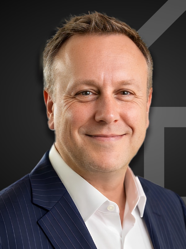 Jeff Karman, Loan Officer at Kash Mortgage Group, smiling in a professional suit against a dark background, representing expertise in mortgage services.